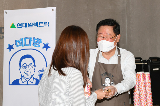 조석(왼쪽) 현대일렉트릭 대표이사가 분당사무소에서 출근길 직원들에게 도넛과 커피를 전달하며 인사를 건네고 있다. <현대일렉트릭 제공>